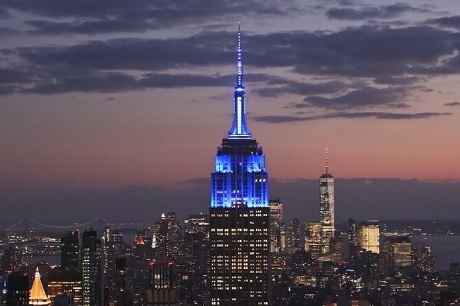 The Art Deco spire on 34th Street lit blue above Midtown at dusk