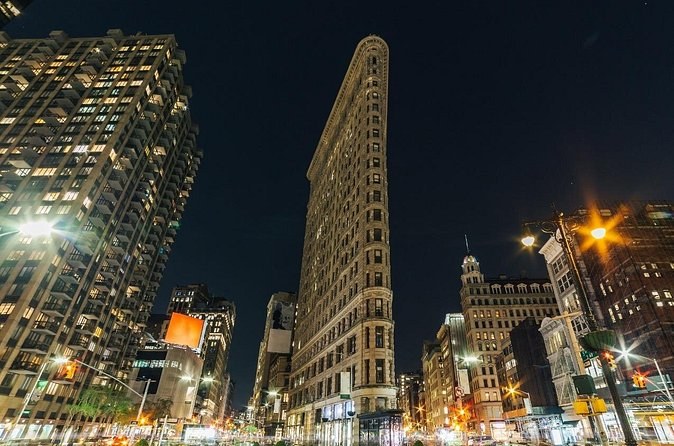 The Flatiron Building's narrow prow and the lights of Fifth Avenue at night