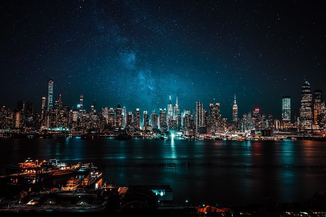 The Manhattan skyline from the New Jersey shore at night, lights on the river