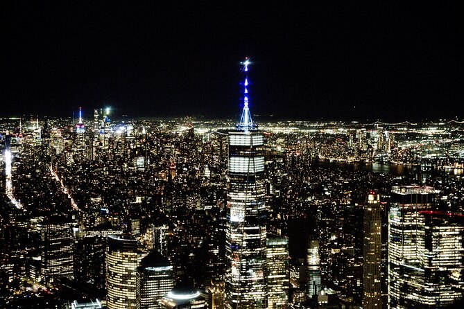 One World Trade Center's lit spire and the grid of Manhattan from the air at night
